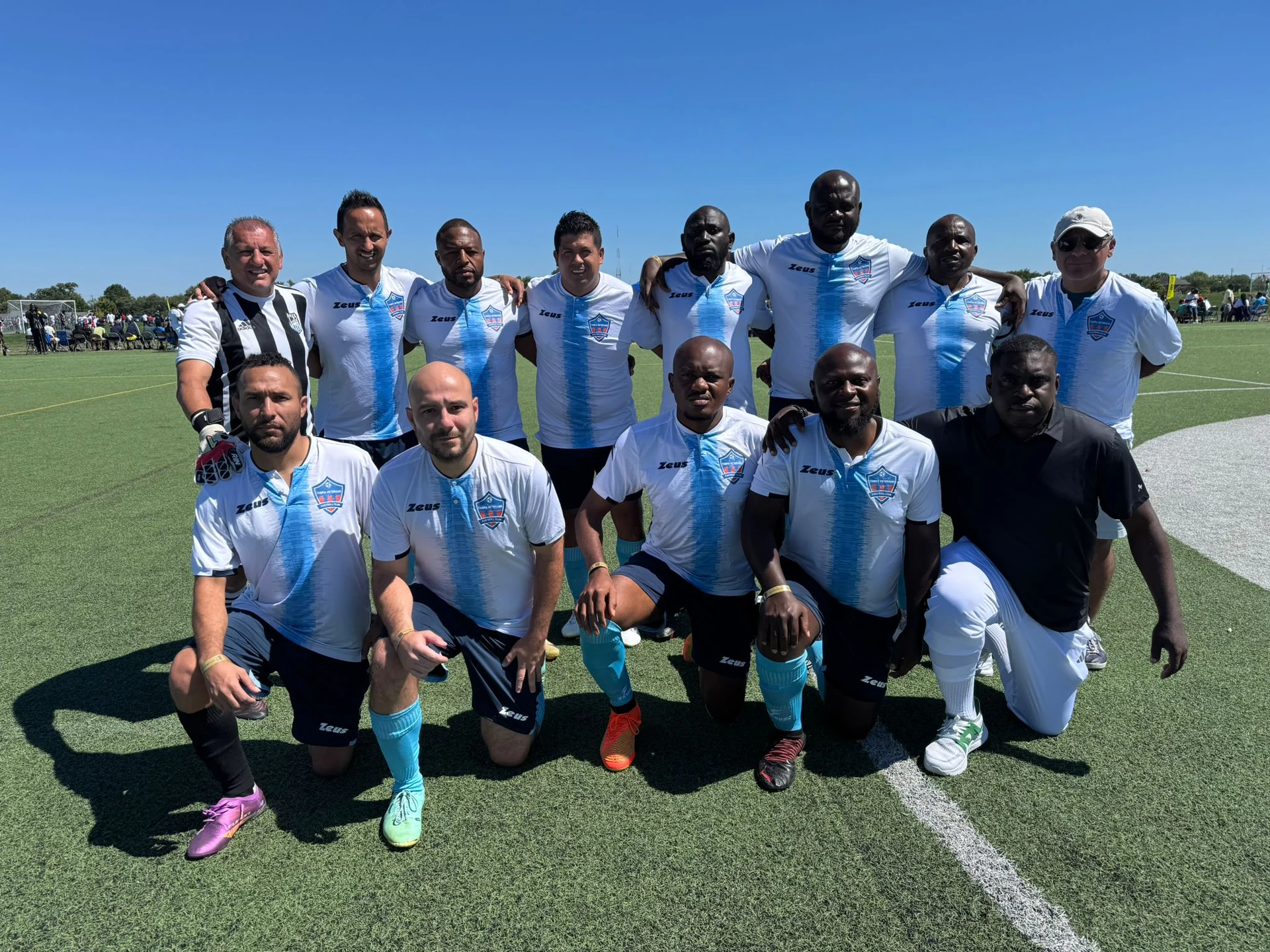 Football players posing in white and light blue kits