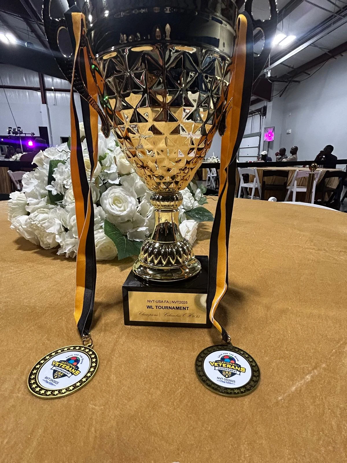 A gold trophy with two medals