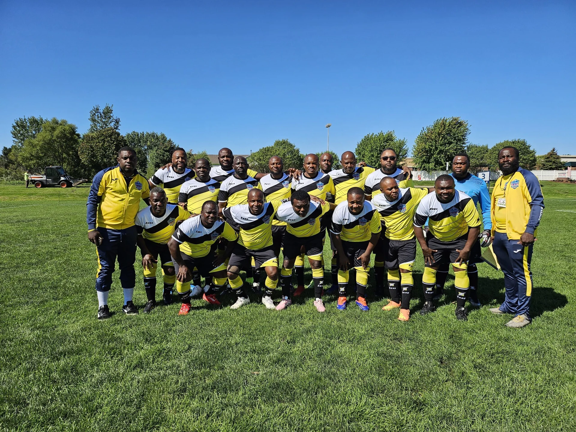 Football team posing together in yellow and black kits