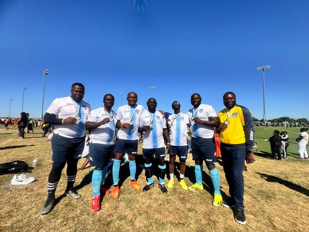 Football players posing in white and light blue kits